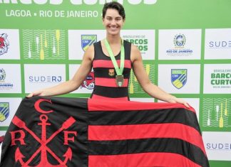 Atleta Yanka Britto segurando bandeira do Flamengo no pódio
