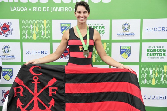 Atleta Yanka Britto segurando bandeira do Flamengo no pódio